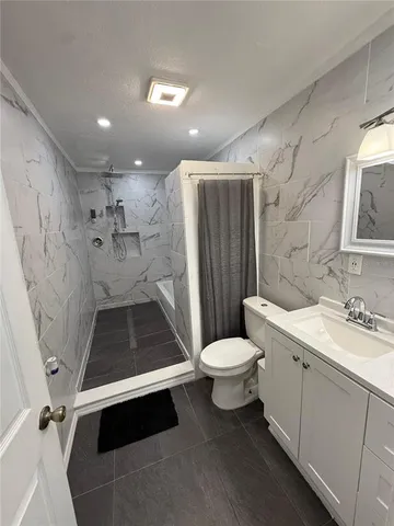 a bathroom with a double vanity sink toilet and shower