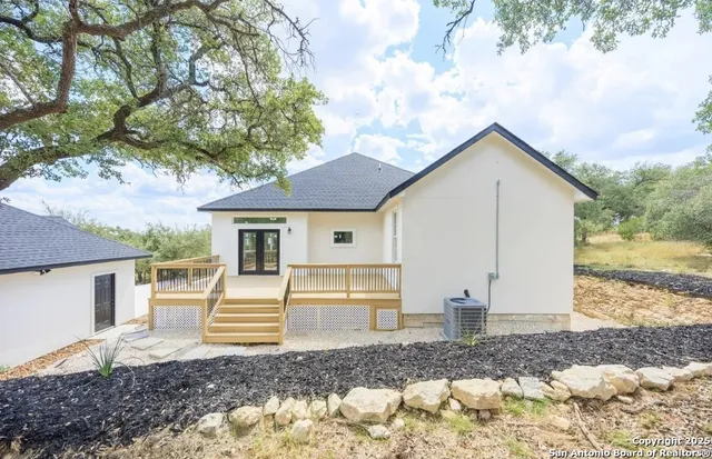 a view of a house with a yard and large tree