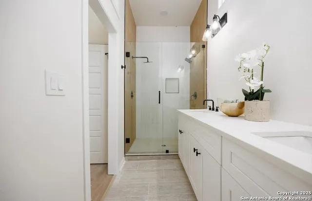 a bathroom with a double vanity sink and mirror