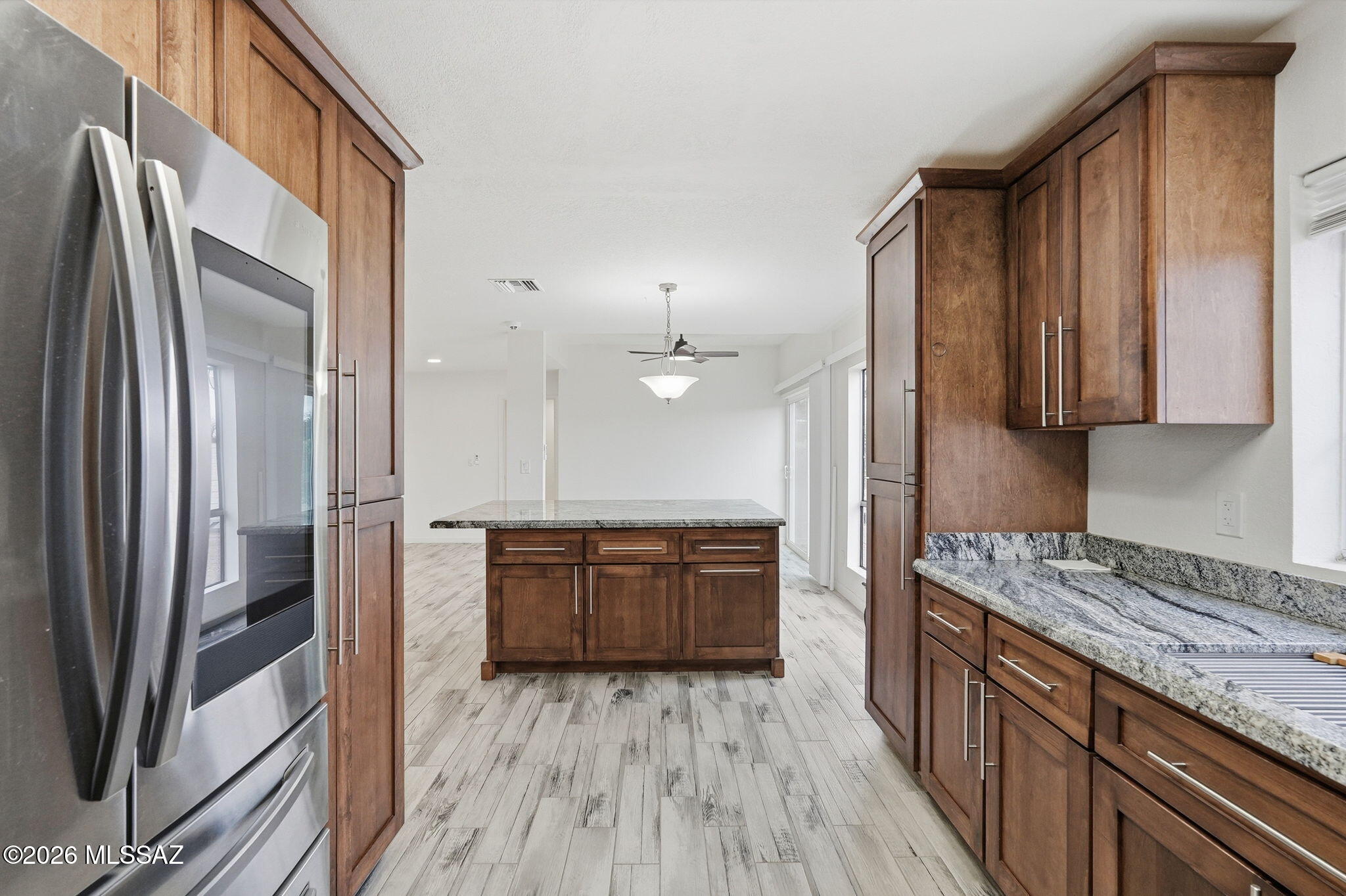 1183 Circulo Canario Rio Rico, AZ 85648 - Photo 8 of 31 a kitchen with stainless steel appliances granite countertop a refrigerator a sink dishwasher a stove and white countertops with wooden floor