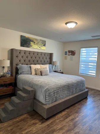 a bedroom with bed and painting on the wall