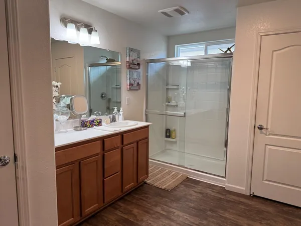 a bathroom with a sink and mirror with shower