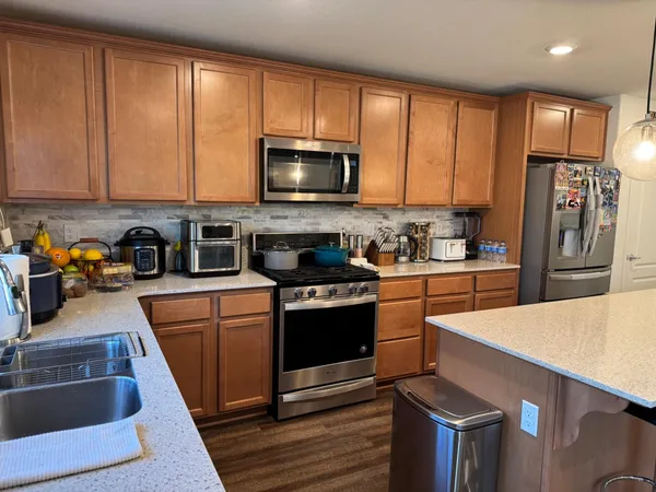 a kitchen with stainless steel appliances granite countertop a refrigerator stove and sink
