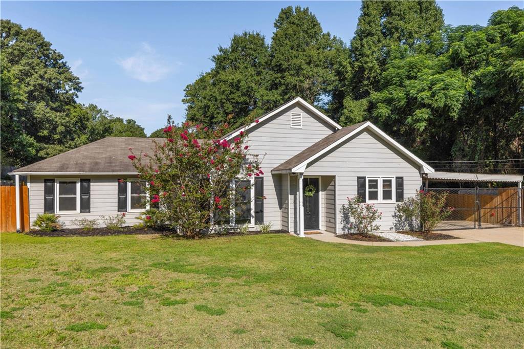 4 Ford Road Phenix City, AL 36869 - Photo 2 of 52 Light gray siding exterior with dark shutters, white trim, covered front entry, and an attached carport