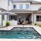a view of a house with backyard and sitting area