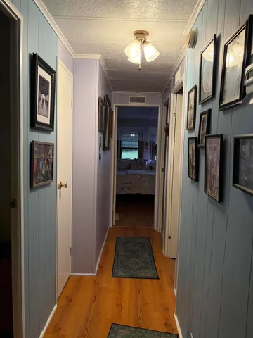 a view of a hallway with wooden floor and staircase