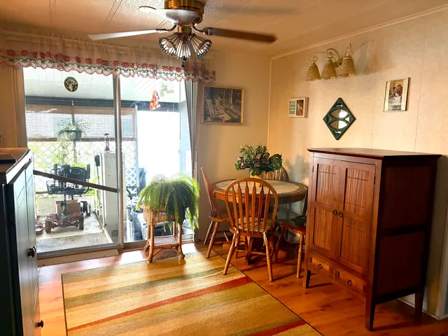 a dining room with furniture a chandelier and wooden floor