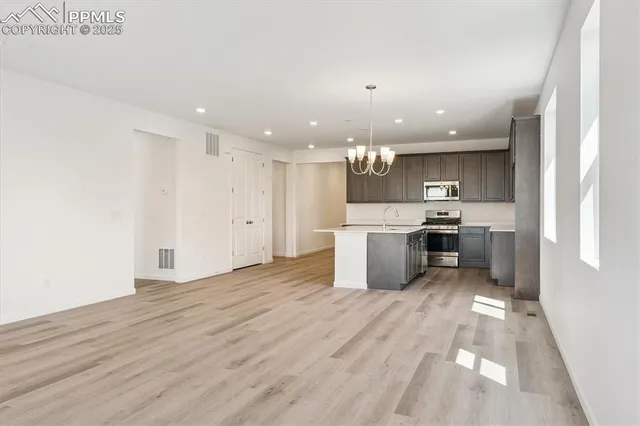 a large kitchen with stainless steel appliances kitchen island a large counter top and a stove top oven