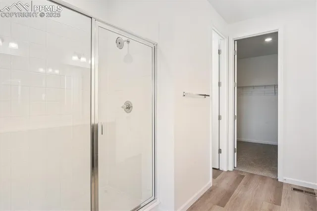 a bathroom with a shower and a glass door