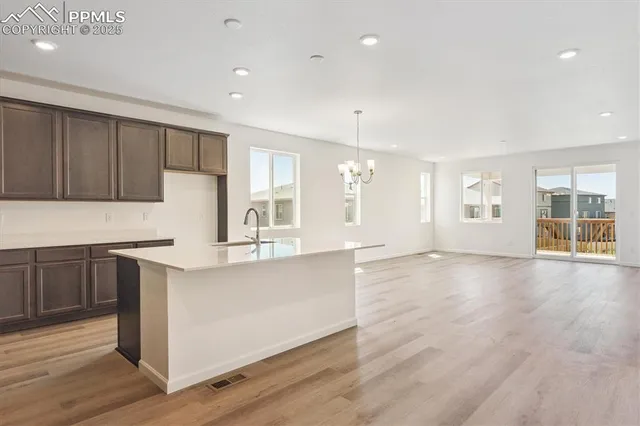 a large kitchen with stainless steel appliances granite countertop a large counter top and wooden floors