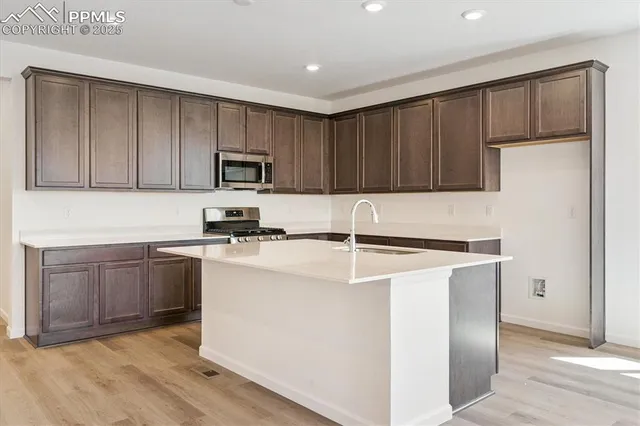 a kitchen with granite countertop wooden cabinets and a stainless steel appliances