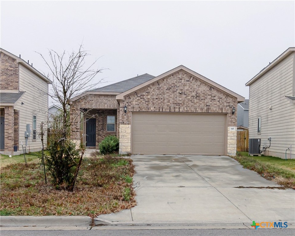 a front view of a house with garage and yard