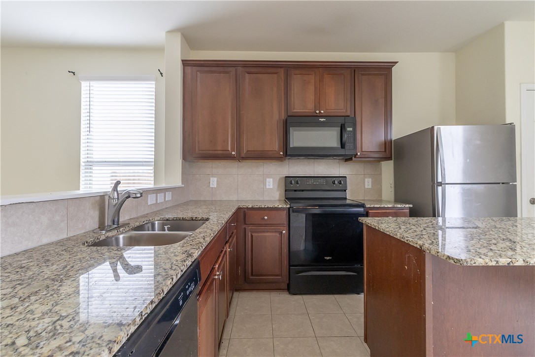 145 Miracle Drive Jarrell, TX 76537 - Photo 11 of 23 a kitchen with a refrigerator sink and microwave
