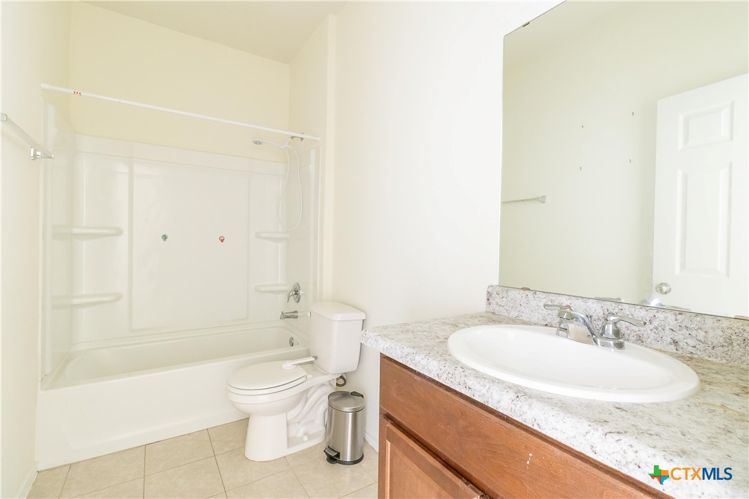 145 Miracle Drive Jarrell, TX 76537 - Photo 15 of 23 a bathroom with a granite countertop sink a toilet and shower