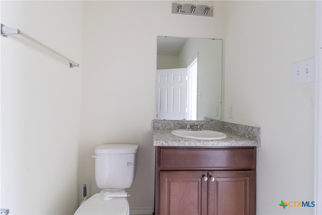 145 Miracle Drive Jarrell, TX 76537 - Photo 19 of 23 a bathroom with a granite countertop toilet and a sink