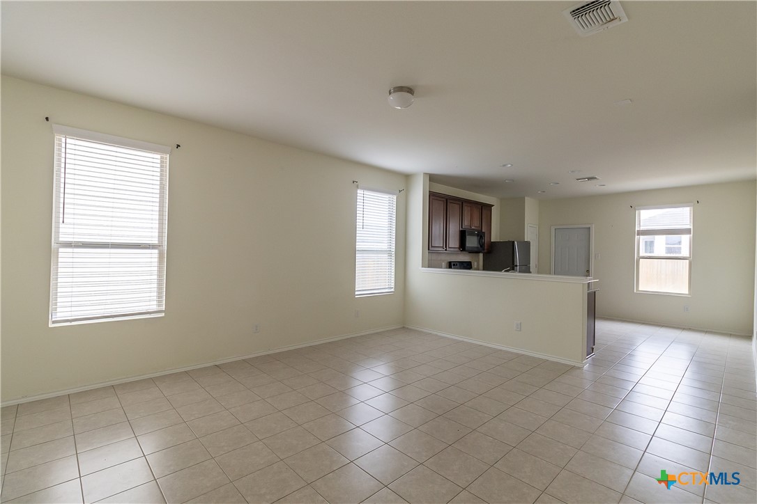 145 Miracle Drive Jarrell, TX 76537 - Photo 5 of 23 a view of empty room with kitchen and window