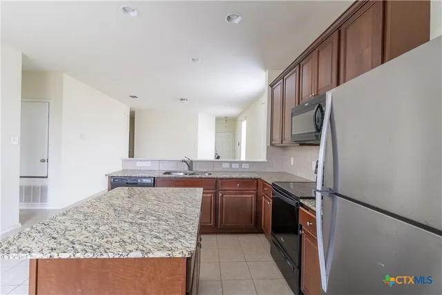 a kitchen with a refrigerator sink and microwave