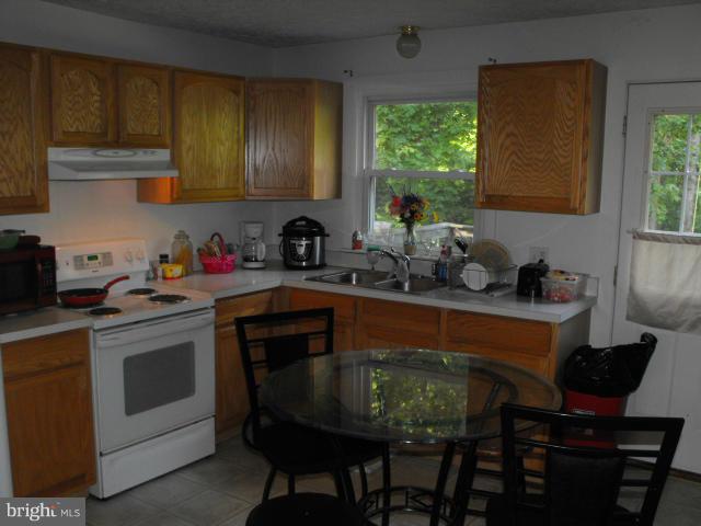 245 Tate Road Prince Frederick, MD 20678 - Photo 4 of 15 a kitchen with a stove a sink and chairs
