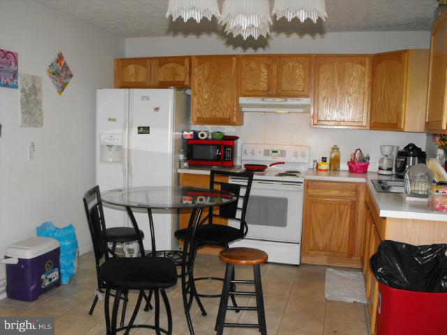 245 Tate Road Prince Frederick, MD 20678 - Photo 5 of 15 a kitchen with stainless steel appliances a refrigerator and a stove top oven