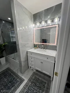 a bathroom with a double vanity sink a mirror and a shower