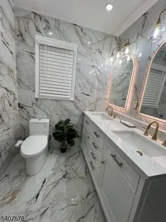 a bathroom with a double vanity sink mirror and toilet