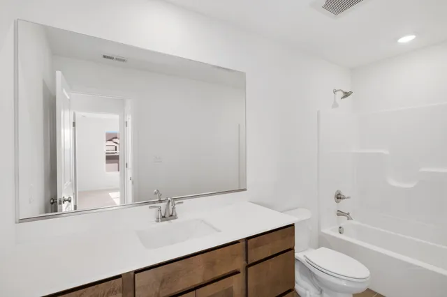 a bathroom with a sink vanity mirror and toilet