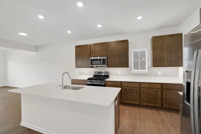 a kitchen with stainless steel appliances a sink stove and cabinets