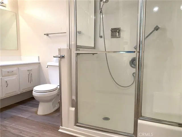 a bathroom with a granite countertop shower a toilet and a sink