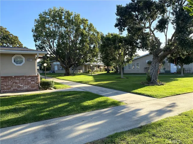 a view of a house with a big yard and large trees