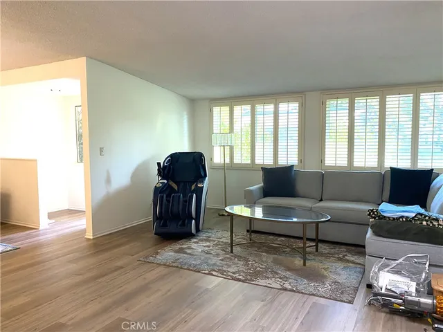a living room with furniture and a hard wood floor