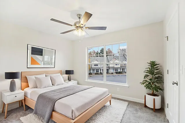 a bedroom with a large bed and a potted plant
