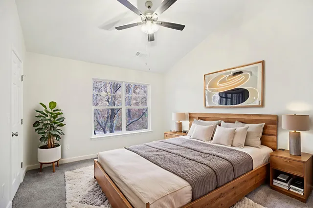 a bedroom with a large bed and a potted plant