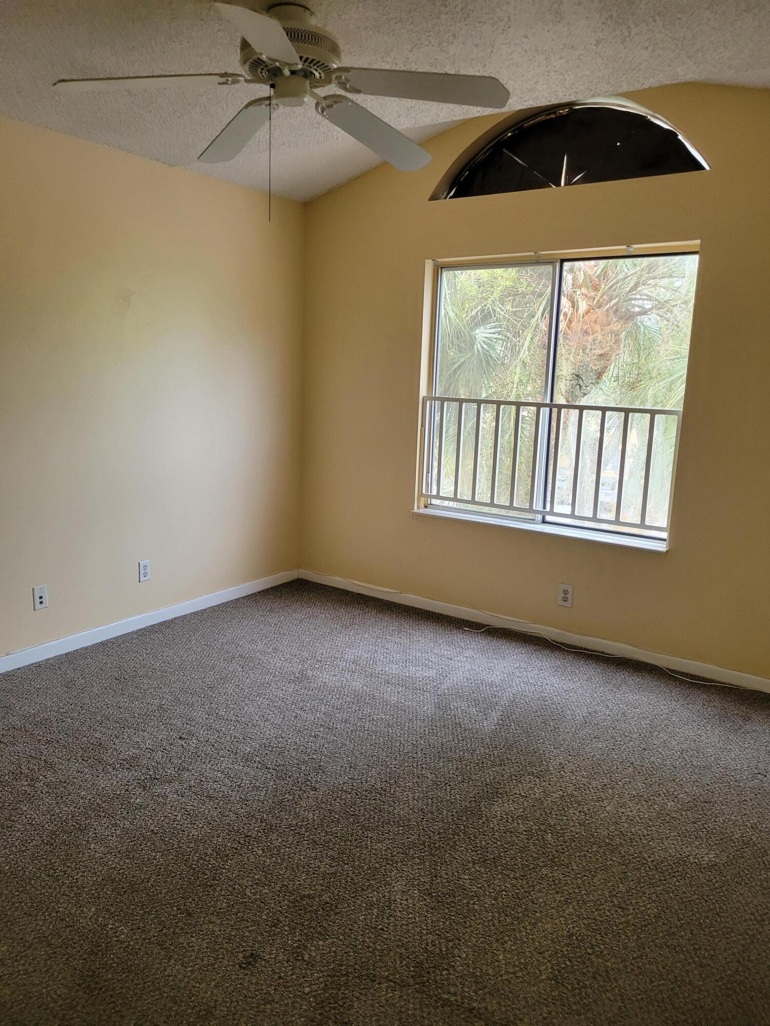 1112 Coral Club Drive, Unit 1112 Coral Springs, FL 33071 - Photo 13 of 16 an empty room with a window and a fan