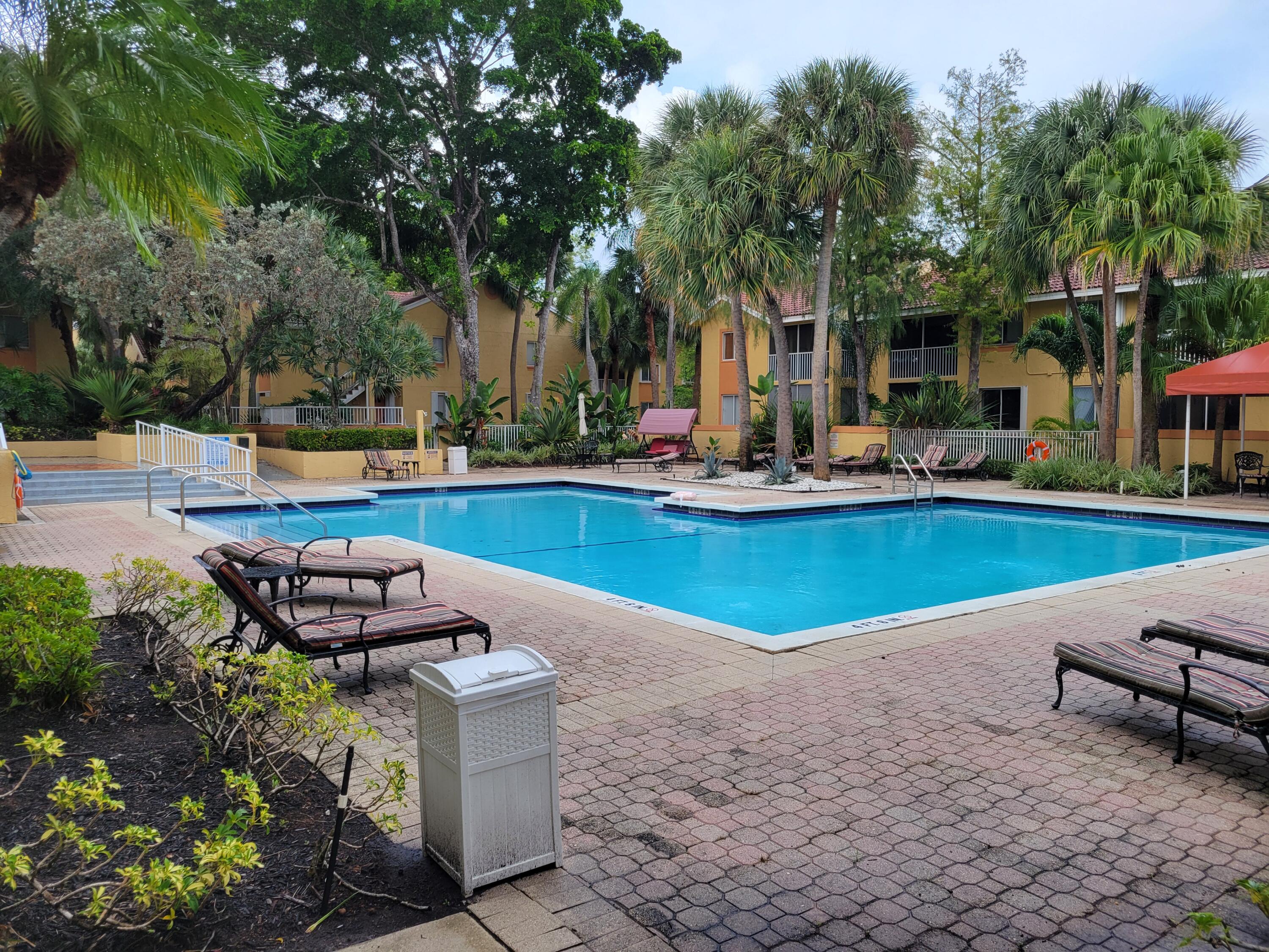 1112 Coral Club Drive, Unit 1112 Coral Springs, FL 33071 - Photo 16 of 16 a view of a house with swimming pool and sitting area