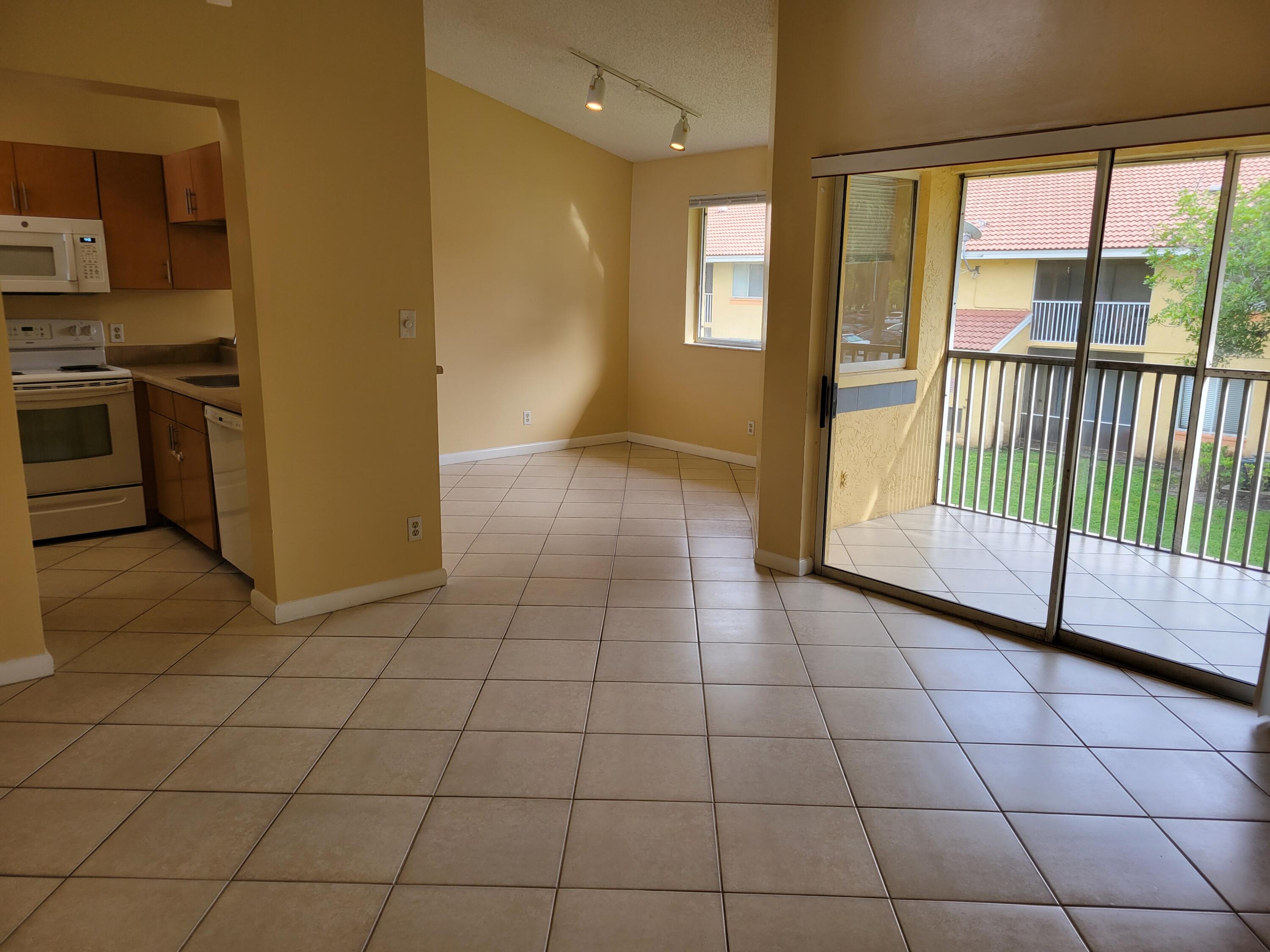 1112 Coral Club Drive, Unit 1112 Coral Springs, FL 33071 - Photo 3 of 16 a view of a kitchen with windows and an empty room