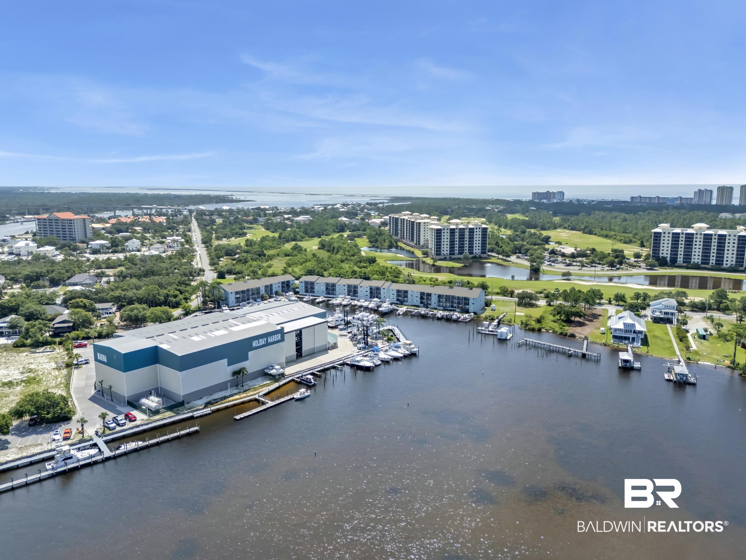 14100 River Road, Unit 211 Pensacola, FL 32507 - Photo 38 of 56 Expansive waterfront property featuring a large marina, multiple boat slips, and a substantial boat storage facility