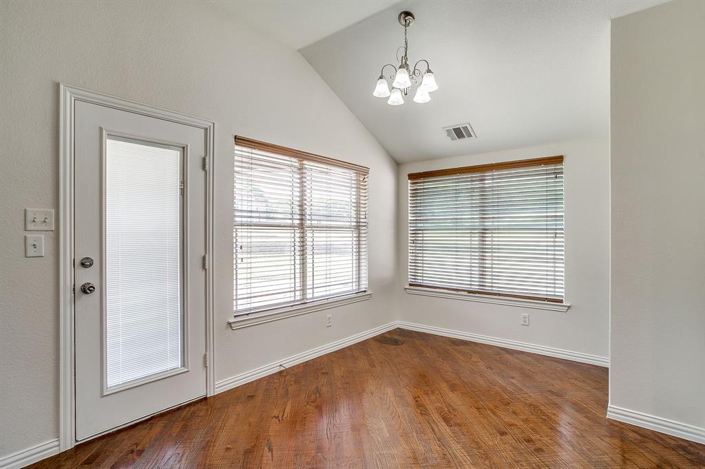 209 Cooperstown Drive Springtown, TX 76082 - Photo 12 of 40 Unfurnished dining area with lofted ceiling, plenty of natural light, dark wood-type flooring, and a chandelier