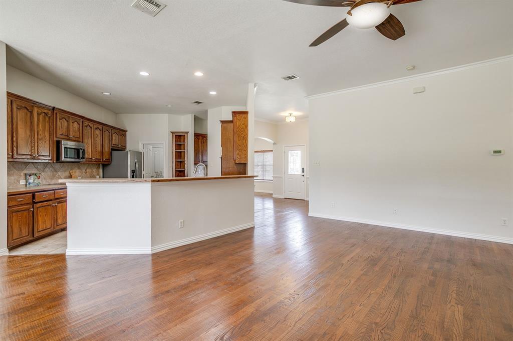 209 Cooperstown Drive Springtown, TX 76082 - Photo 13 of 40 Kitchen with brown cabinets, tasteful backsplash, light wood-style flooring, recessed lighting, and a ceiling fan
