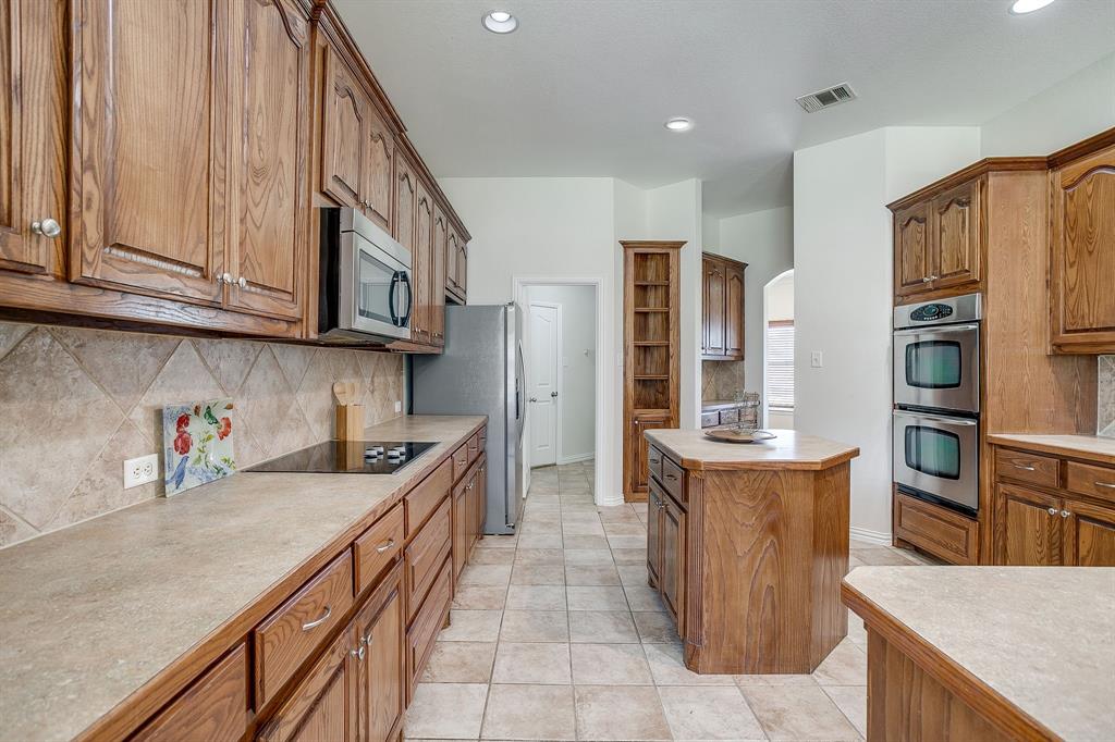 209 Cooperstown Drive Springtown, TX 76082 - Photo 14 of 40 Kitchen with backsplash, brown cabinetry, light countertops, and recessed lighting