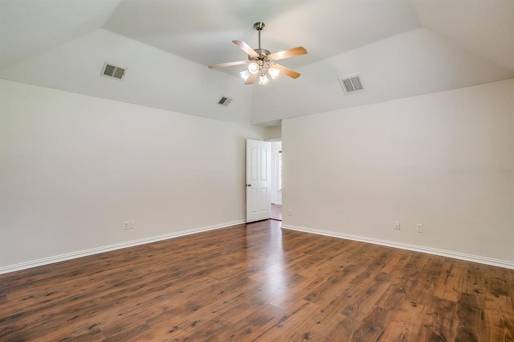 209 Cooperstown Drive Springtown, TX 76082 - Photo 20 of 40 Empty room with dark wood-style flooring, vaulted ceiling, and a ceiling fan