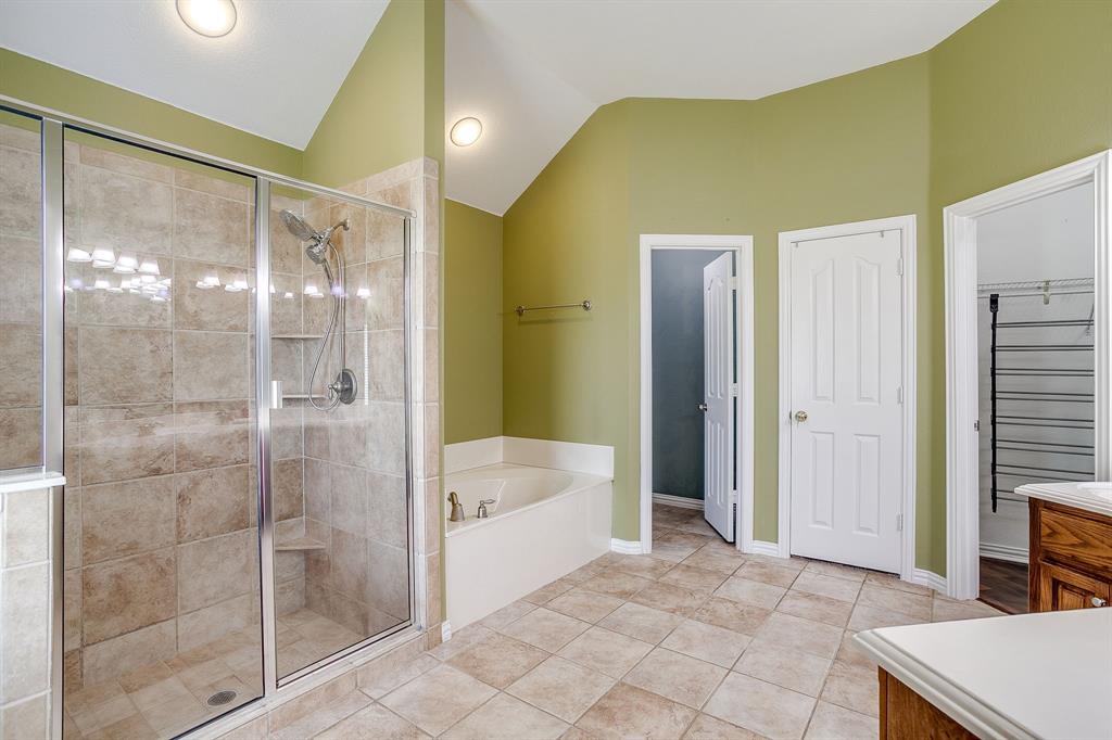 209 Cooperstown Drive Springtown, TX 76082 - Photo 22 of 40 Full bathroom with a stall shower, a garden tub, vaulted ceiling, light tile patterned floors, and recessed lighting