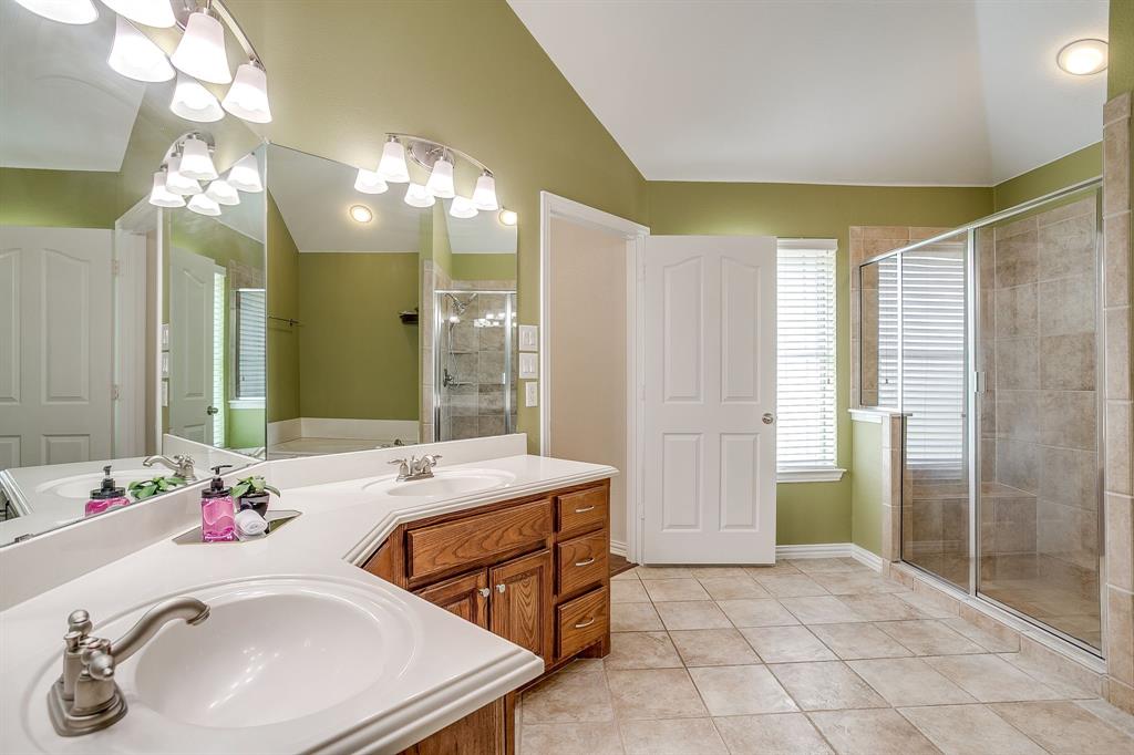 209 Cooperstown Drive Springtown, TX 76082 - Photo 25 of 40 Full bathroom with light tile patterned floors, double vanity, a stall shower, and lofted ceiling