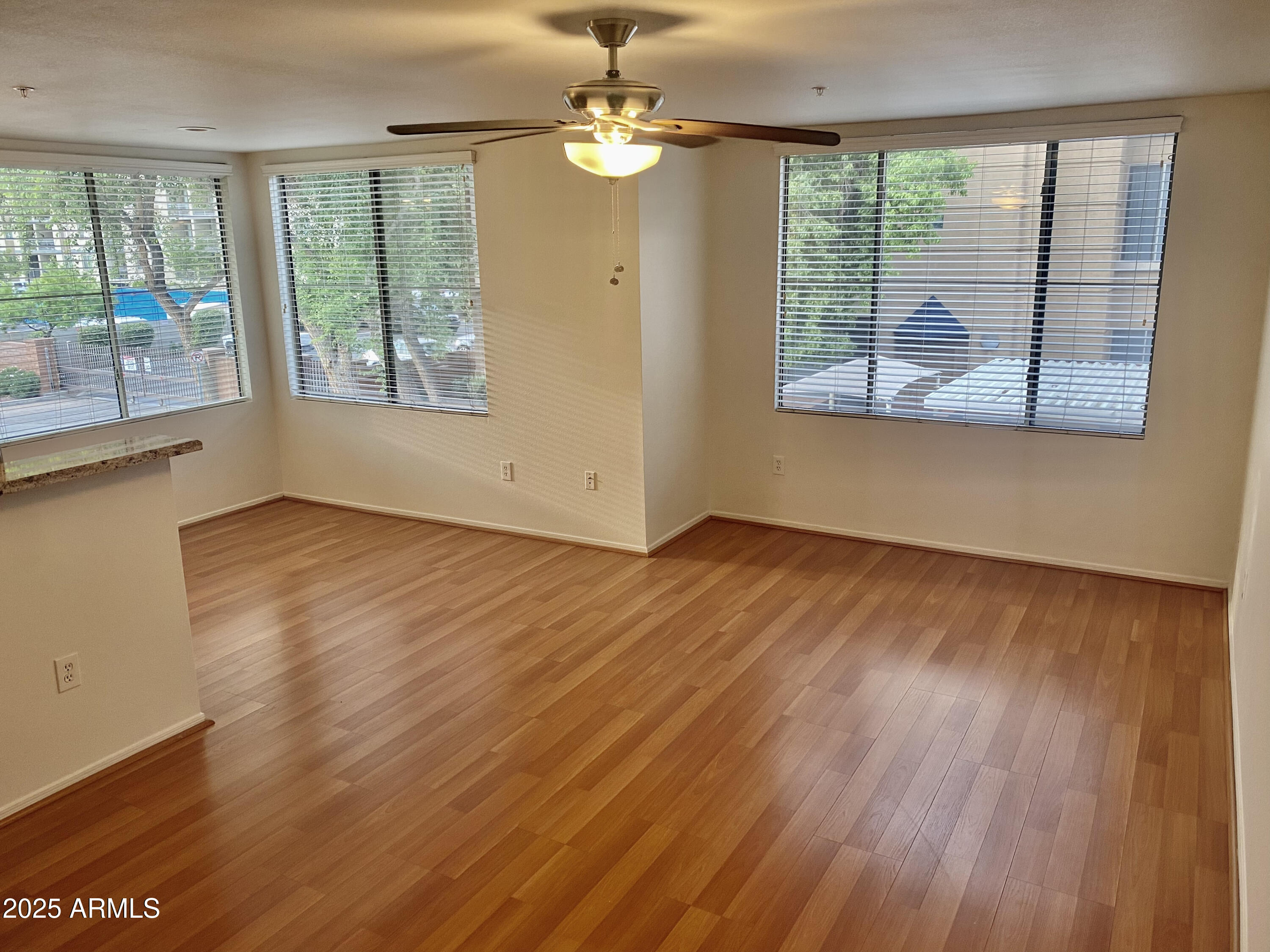 1701 East Colter Street, Unit 1 Phoenix, AZ 85016 - Photo 6 of 17 a view of an empty room with wooden floor and a window