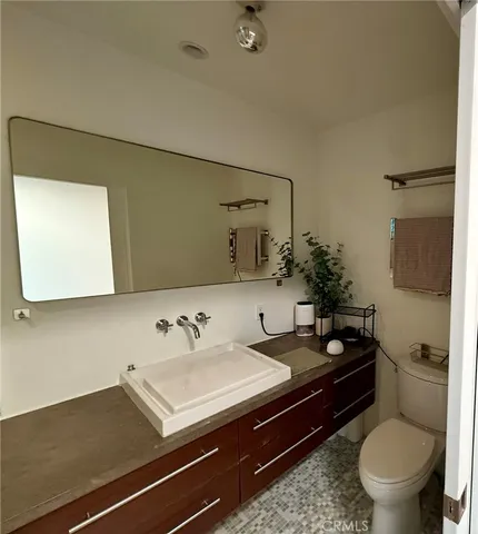 a bathroom with a sink a toilet and mirror