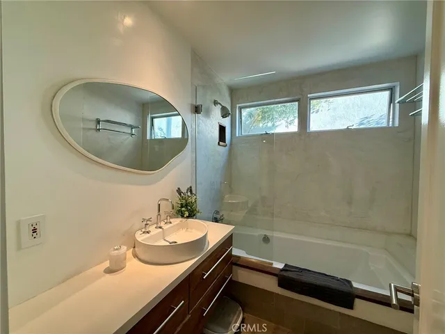 a bathroom with a sink a mirror and a bathtub