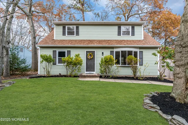 a front view of a house with a garden and yard