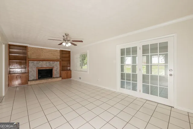 a view of an empty room with a fireplace and a window
