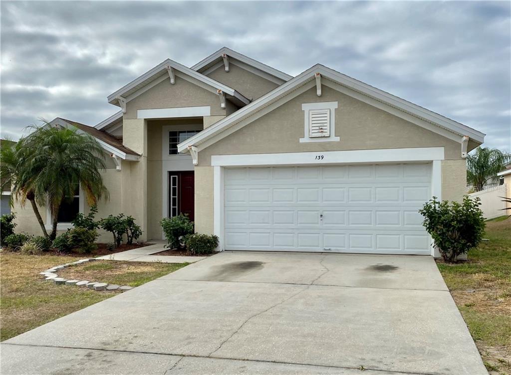139 Argyle Gate Loop Road Dundee, FL 33838 - Photo 1 of 1 a front view of a house with a yard and garage