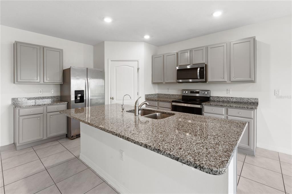 2651 Grandbury Grove Road Lakeland, FL 33811 - Photo 2 of 41 a kitchen with stainless steel appliances granite countertop a sink stove and refrigerator