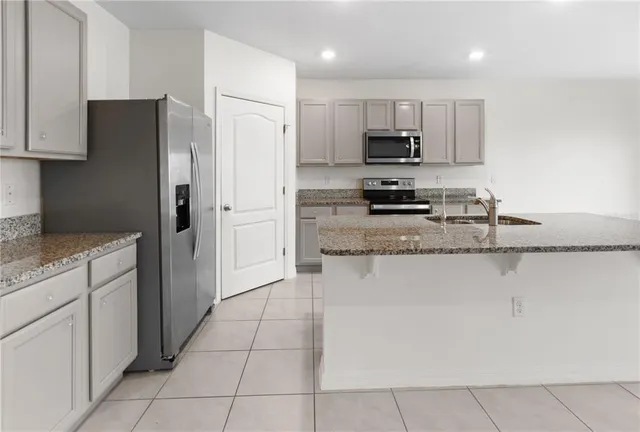 a kitchen with stainless steel appliances granite countertop a refrigerator and a stove